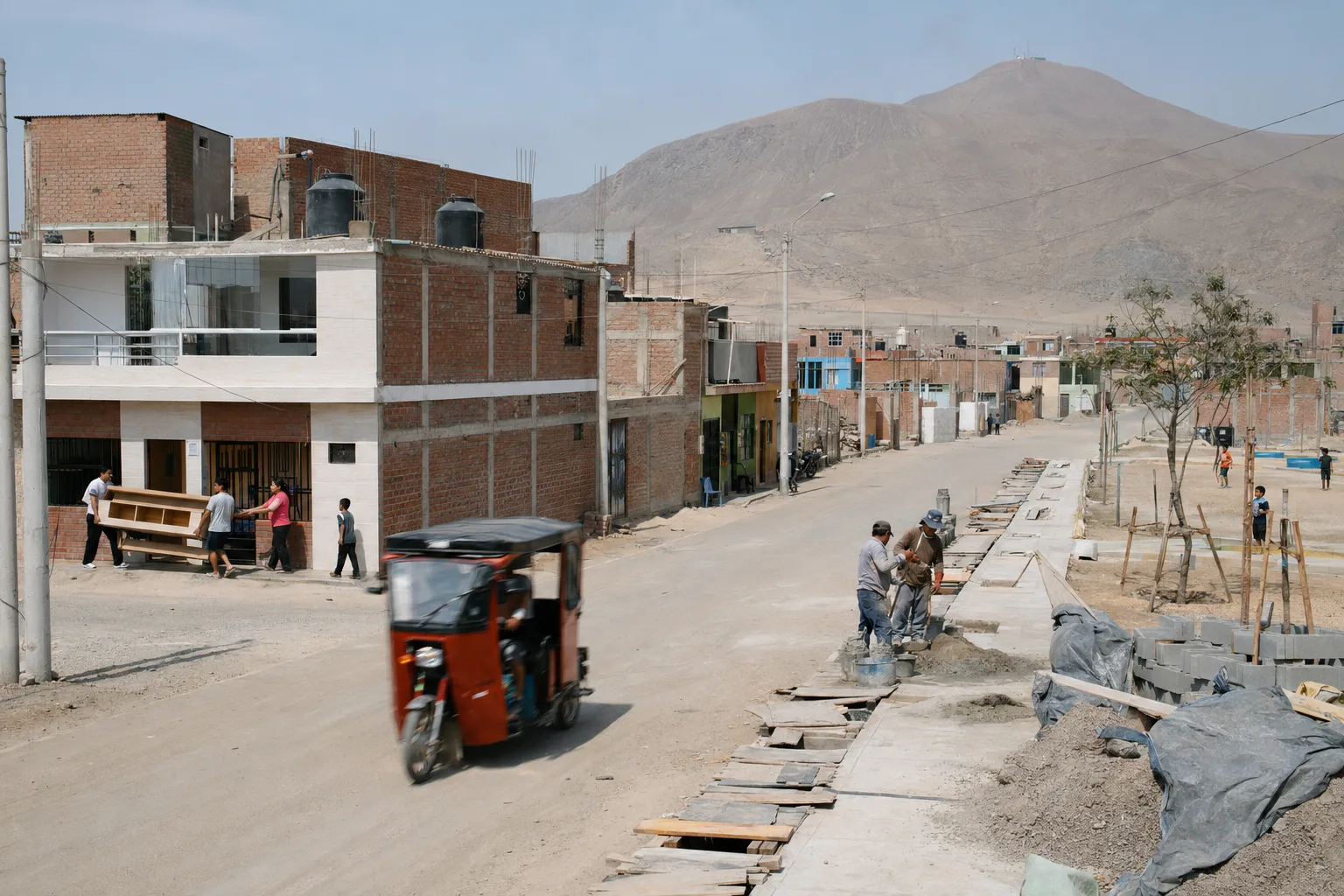 Trabajadores construyen veredas junto a viviendas y mototaxis en Los Pinos
